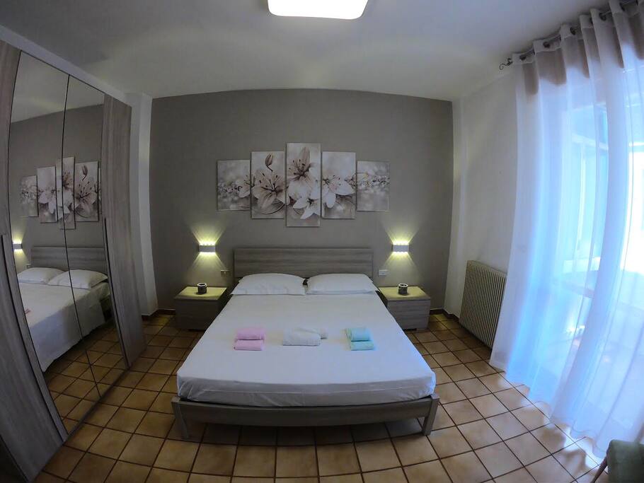 Camera da letto 1
La stanza è composta da un letto matrimoniale con due cuscini e biancheria letto (1). Due comodini, un armadio, una cassettiera con specchio.