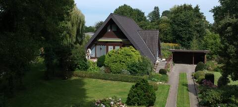 cozy house with outdoor fireplace and garden