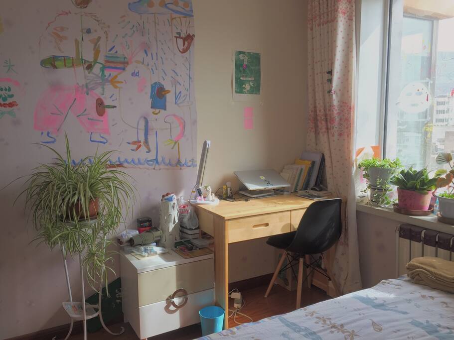 房间里有很多植物。一些书。一张书桌。可以写写画画。