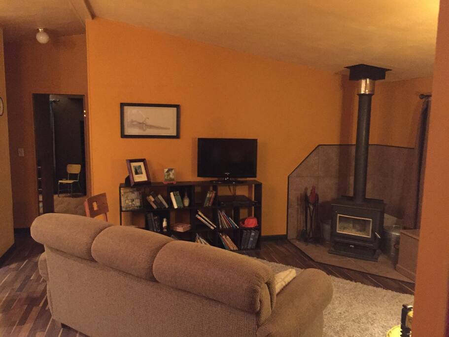 Here is the cozy living room with a wood burning stove to sit around on cold winter evenings and talk or watch a movie around. There are children's books and toys also neatly stowed here to make all guests comfortable.