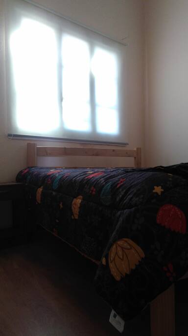 Habitación con cama matrimonial, mesa de noche y armario.