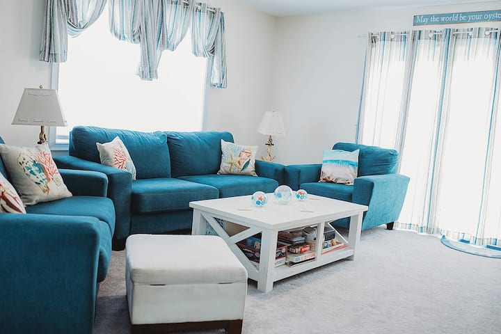 Woonkamer op de tweede verdieping met aan de muur gemonteerde tv en spelletjes