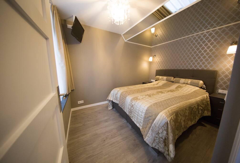 Bedroom with tv and mirror ceiling.