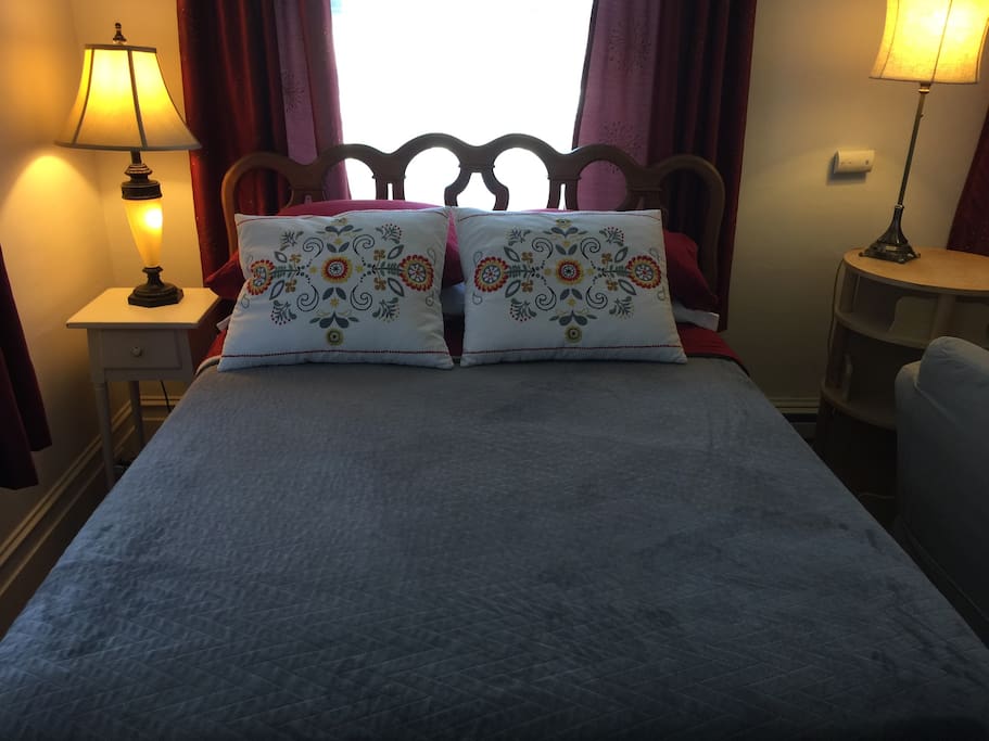 Double bed with layers of blankets with both firm and soft pillows for your comfort.