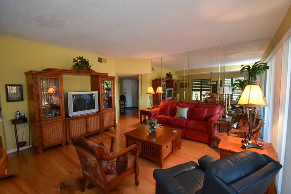 The living area open to the kitchen and dining area. There are sliding doors that lead out to a spacious covered balcony overlooking Neptune.