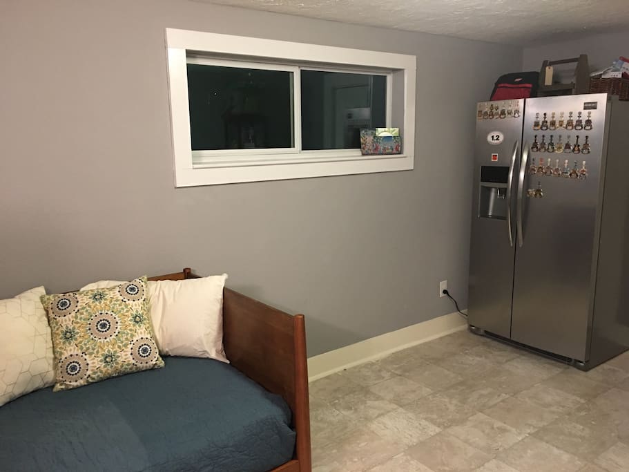 This is a twin size daybed. The dimensions are 38 inches by 75 inches wide. One person can fit comfortably. There is not a pullout piece to it. The window does open by sliding the left window to the right. Feel free to use the fridge if you need to.