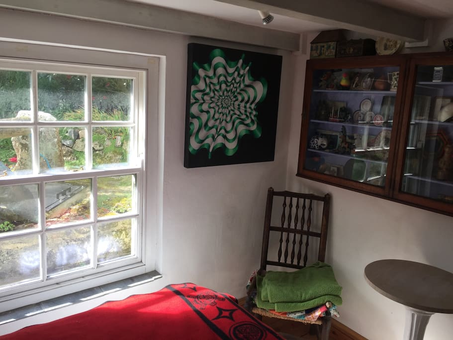 Small cottage bedroom with a Queensize bed. Old stone well outside the window.Private bathroom