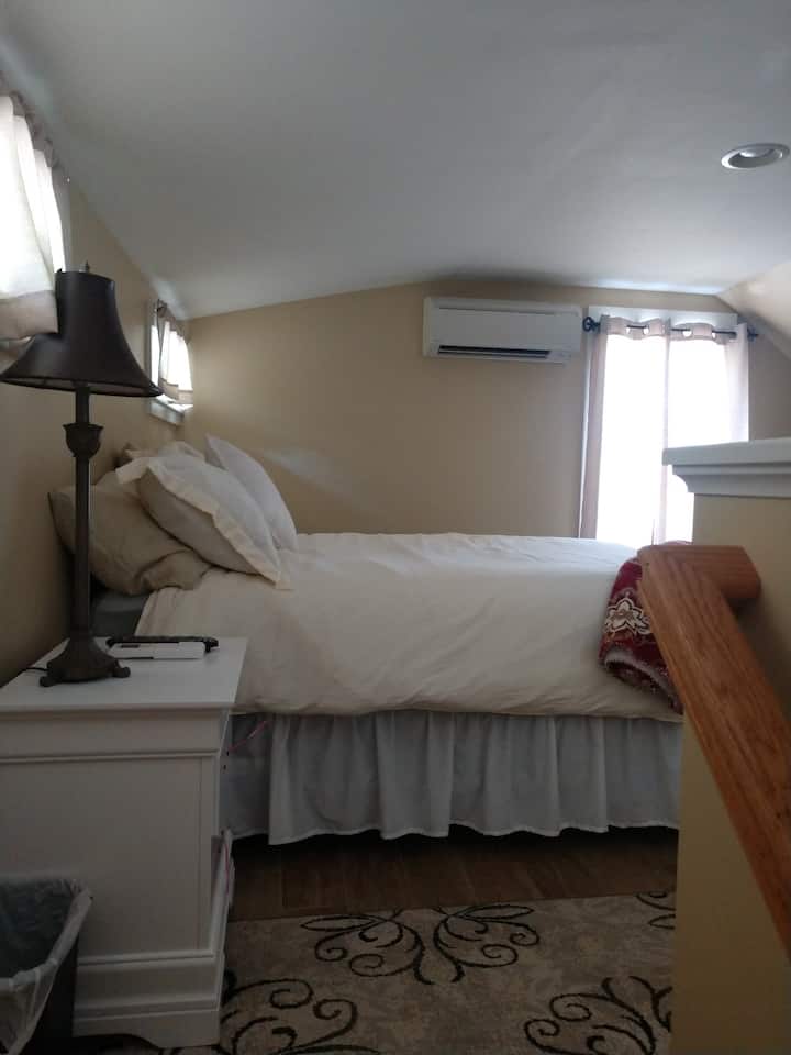 queen bed with air conditioning closet and tv