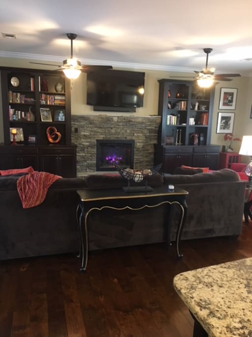 Spacious living room area, with open floor plan. The living room has a love seat that turns into a pull out twin bed. This room is perfect for watching tv and hanging out by the fireplace.