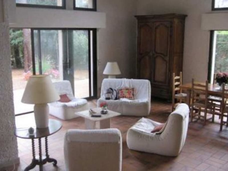 La grande pièce à vivre donnant sur le jardin avec sa grande table, son coin salon et a cheminée