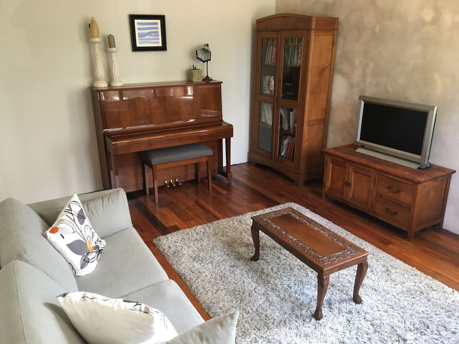 Bedroom 4 with a TV, DVD player, sofa bed, piano and desk.
