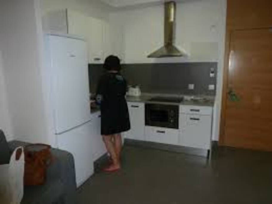 Kitchen with stove, microwave, coffemachine pans and more