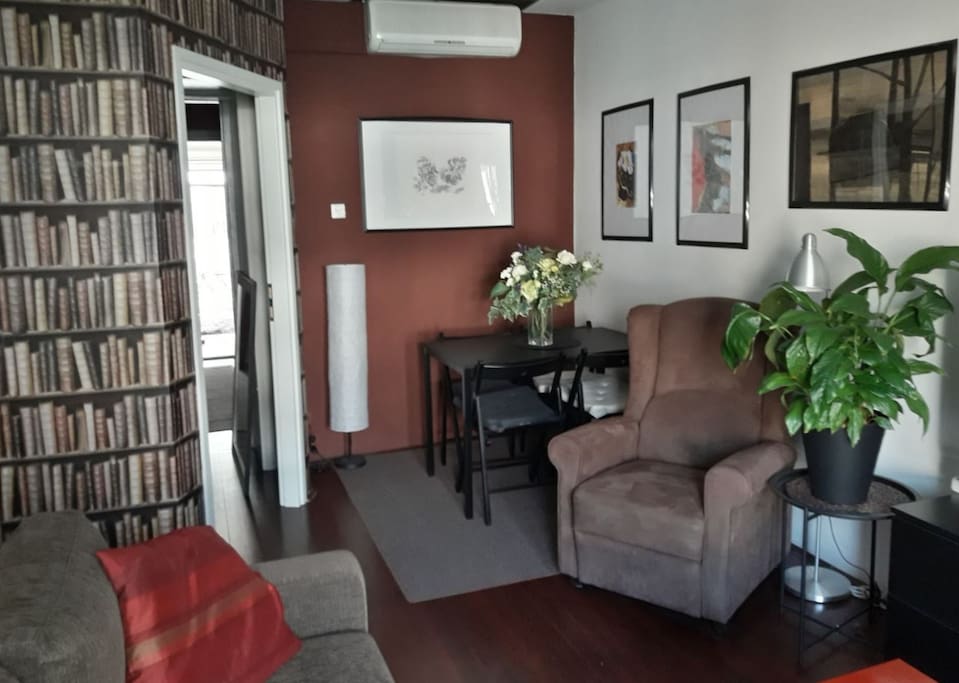 Living room with air conditioning, TV, HIFI and one sofa that can accommodate max two persons.