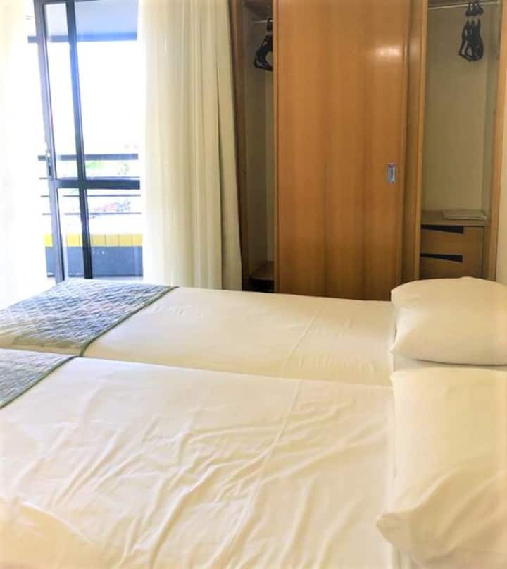 Suite 2 : suite avec 2 lits simples, grand placard, TV et salle de bain privée. Climatiseur pour les fenêtres