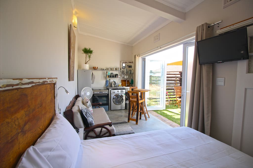 Open plan studio with comfortable queen bed, lounge and eating area and equipped kitchenette