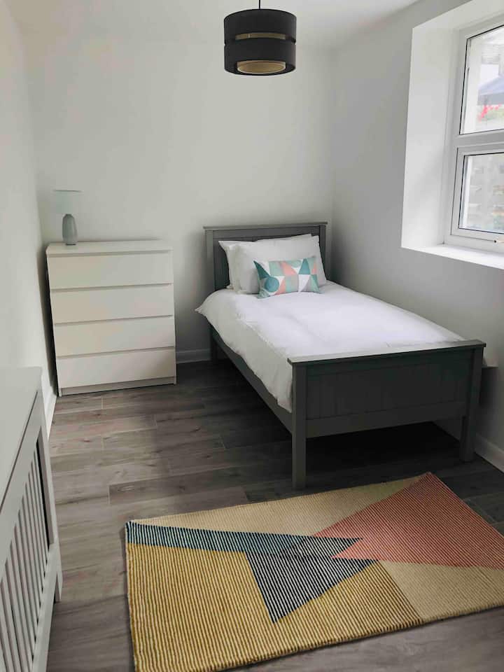 หนึ่งในสองห้องนอนเดี่ยวเราเรียกห้องนี้ว่า “ห้องในสวน” ของเราสว่างและกว้างขวางและตั้งอยู่ด้านหลังของบ้านซึ่งมองเห็นสวน มันรับแสงแดดตลอดช่วงบ่ายและมีวิวหน้าต่างที่สวยงามของดอกกุหลาบของเรา 