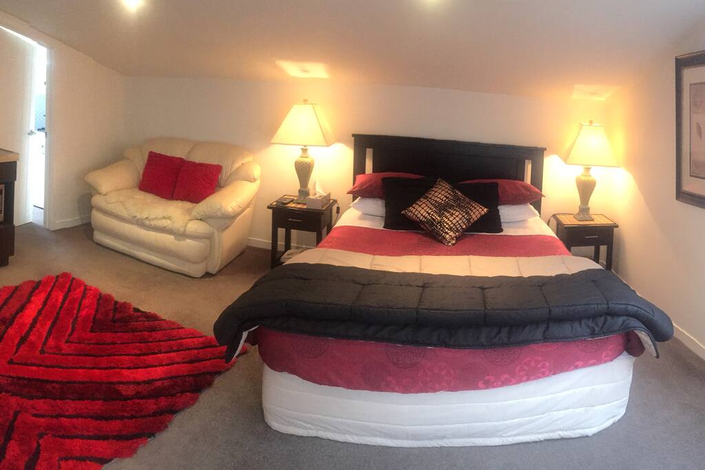 Generous Queen bed with leather couch.
