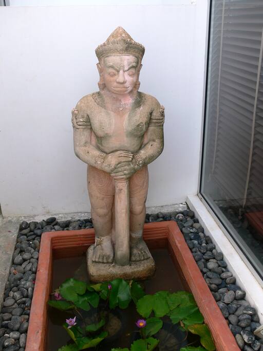 Terracota guard at apartment welcomes guests and frowns on strangers.