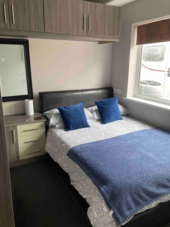 El tercer dormitorio está al lado de la casa con cama doble, persiana opaca, televisión y armarios empotrados.