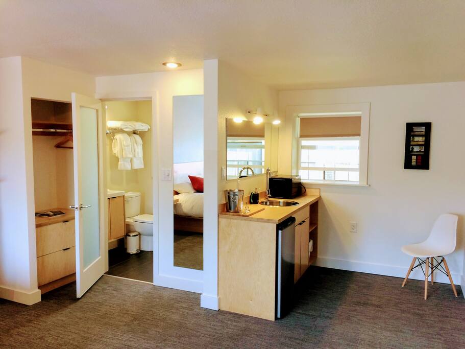 Custom built closet, and wet bar with storage, microwave, sink, refrigerator.