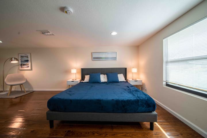 Apartmán s hlavnou spálňou s manželskou posteľou King, bočnou stoličkou na čítanie, hlavnou skriňou a 65-palcovým televízorom Roku. 