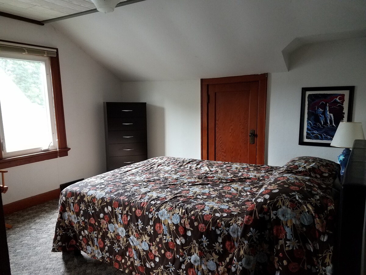 غرفة نوم مع خزانة ملابس وخزانة ملابس ومنضدة ليلية