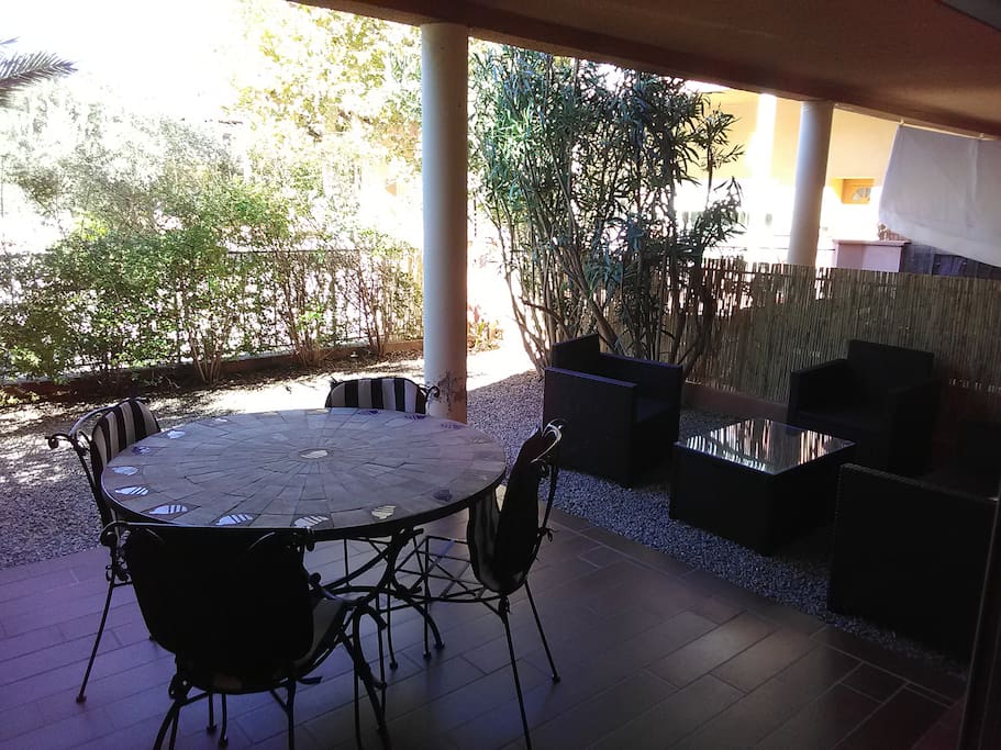 Cour arrière avec terrasse couverte et salon de jardin