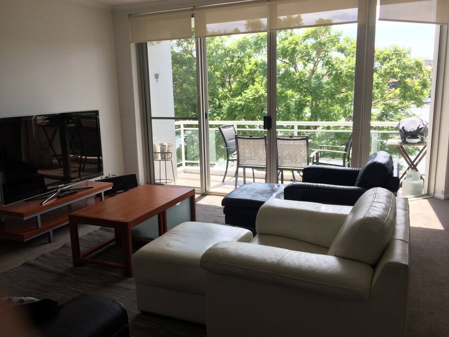 Lounge room with HDTV, comfortable leather chairs and bluetooth sound bar.