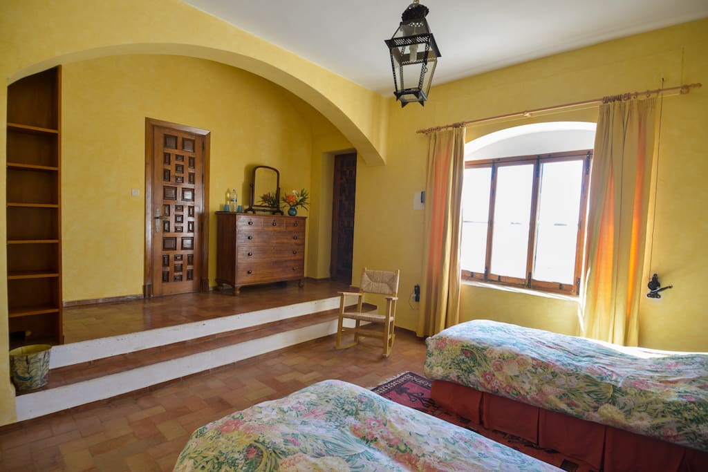 Bedroom with archway and door leading to balcony overlooking the main garden