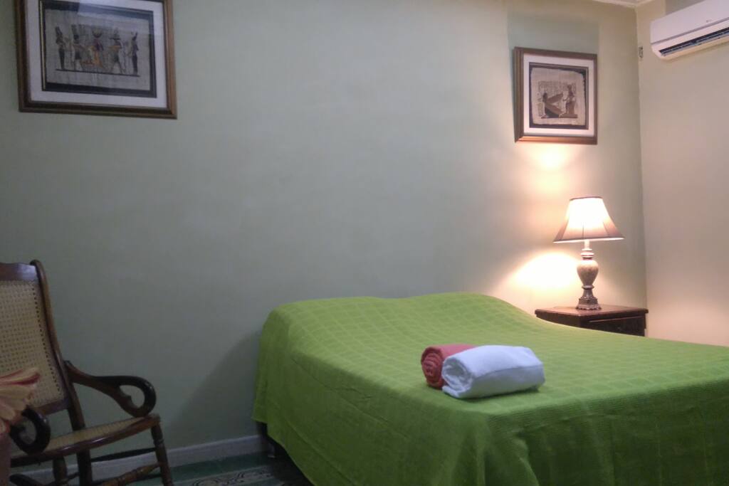 Habitación con una cama doble y una sencilla. Aire acondicionado, armario, nochero, ventilador, TV con Cable, WiFi.