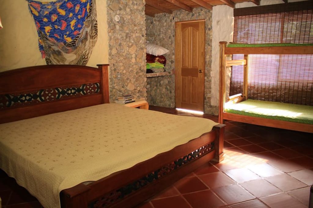 Habitación con cama matrimonial extragrande y camarote.
