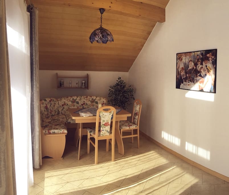 Sehr helles Zimmer mit hocher Decke, bayrische Essecke, Sofabett, TV, Stereo, Balkon
Bright and sunny living and dining room with Bavarian corner dining table, sofa bed, tv, stereo and Balcony