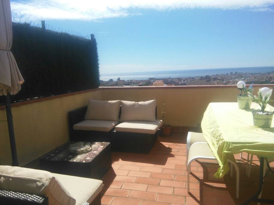 Terrace with lounge, barbecue and dining area with views over the sea