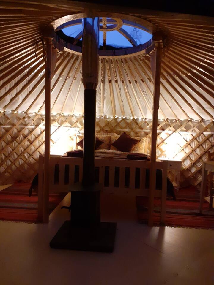 The interior of this Mongolian yurt with natural wood and beautiful golden paintwork