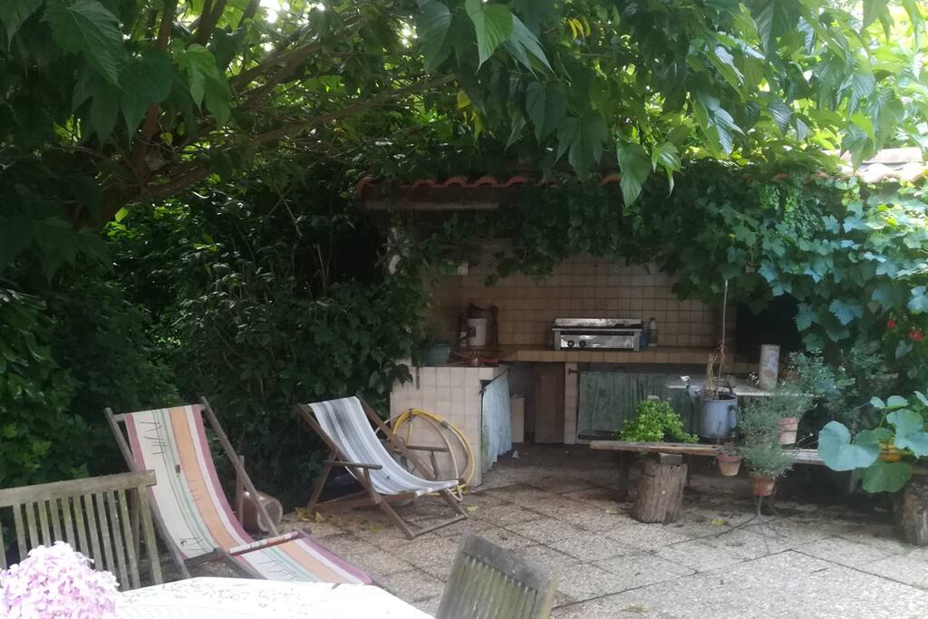 Une terrasse confortable et ombragée, avec sa cuisine américaine, planxa, transats, etc ...
