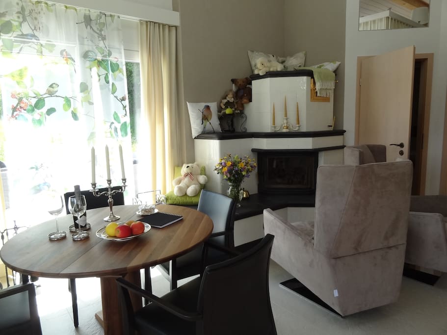 innen Wohnzimmer Esstisch Kachelofen