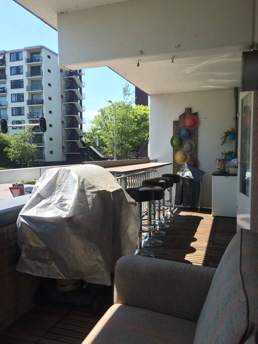 Balcony with bar and stools, fridge, gas bbq and lounge area