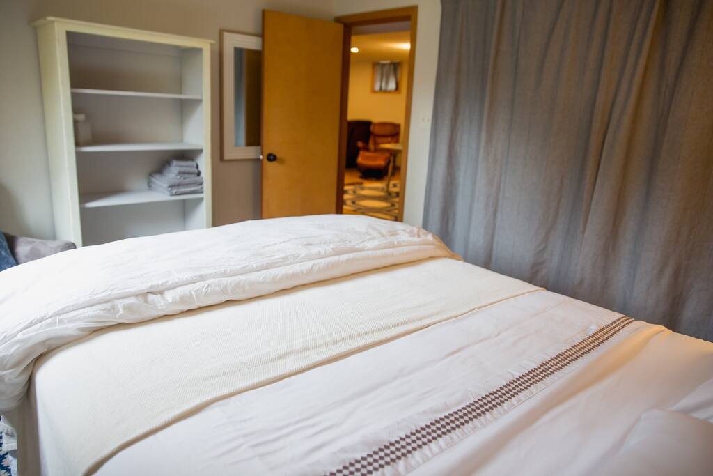 Private room has a queen size bed, closet with hangers, a bed side table, lamp, reading chair, and clothing shelf. There are no TV's in the private rooms.