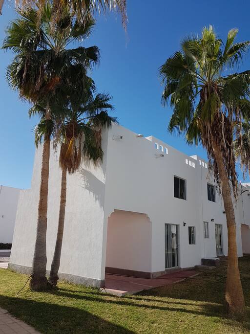 Fachada posterior con área verde y asador