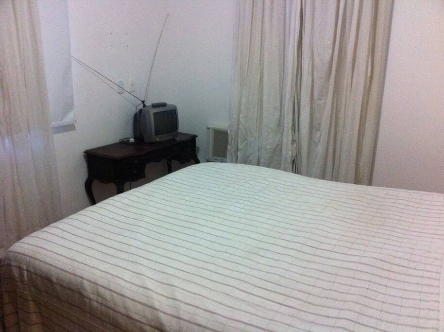 Quarto casal com cama king size e ar condicionado.