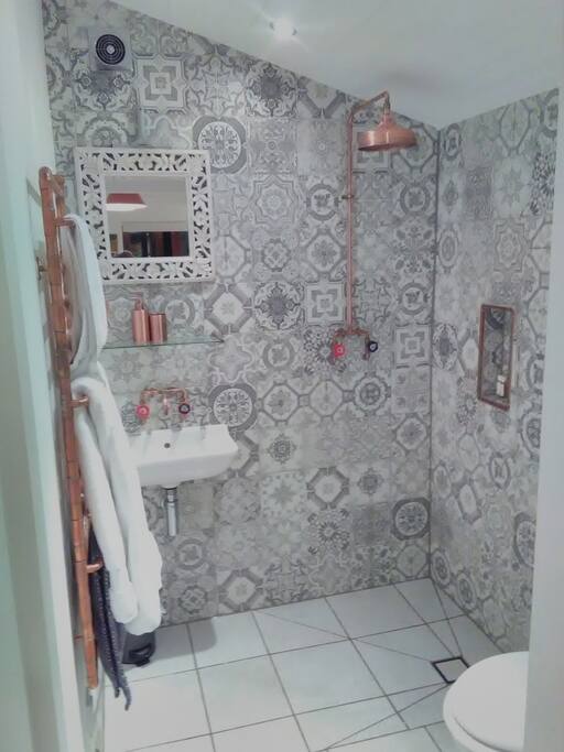 Wet room with underfloor heating with bespoke home made copper taps, shower and radiator