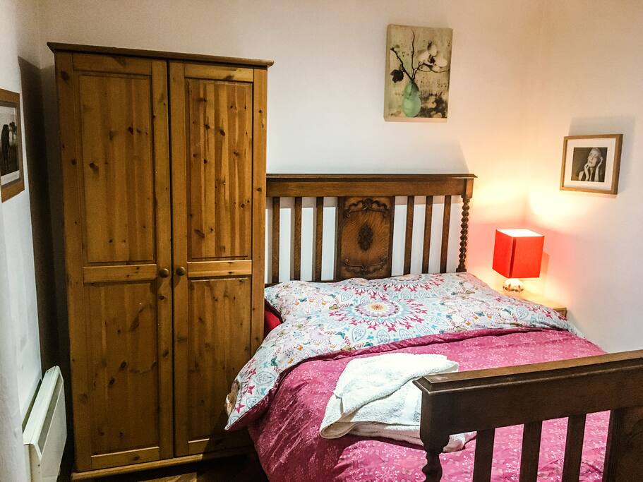 Double bedroom with wardrobe, bedside light. Oak parquet floor.