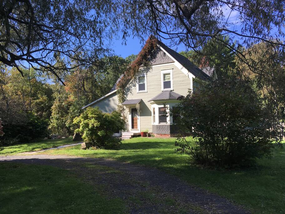 Mature plantings and open fields/yard all around.