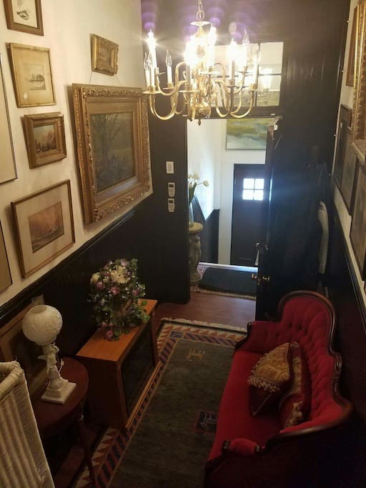 Lovely entranceway into the building filled with artwork, oriental rugs and antique furniture.