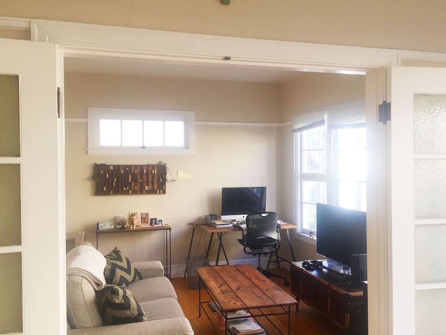 French doors open and close between the living room and bedroom