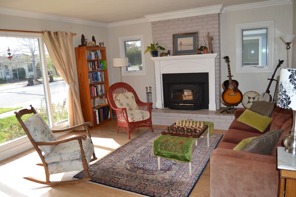 Living room has wood burning fire place and lots of natural light.