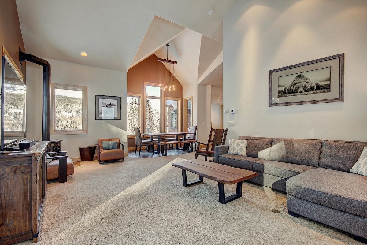 Obývacia izba s krbom a pohovkou s výhľadom na jedálenský kút