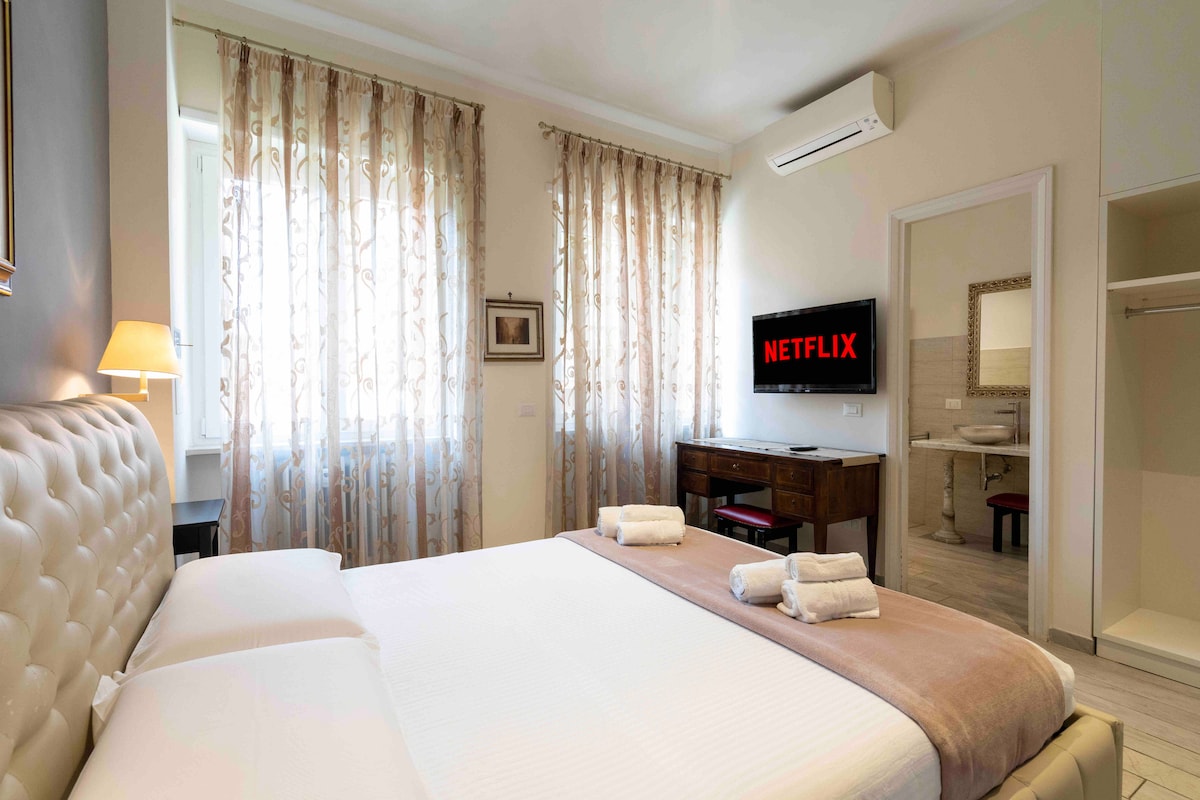 Prvi apartman s vlastitom kupaonicom u sobi.
Apartman se sastoji od:

- bračni krevet (širine 150-179 cm).
-Smart TV Ultra HD 40"
-Scrivania za pametni rad
-Otvorite restoran za odjeću -
Cassaforte - 
klima-uređaj
