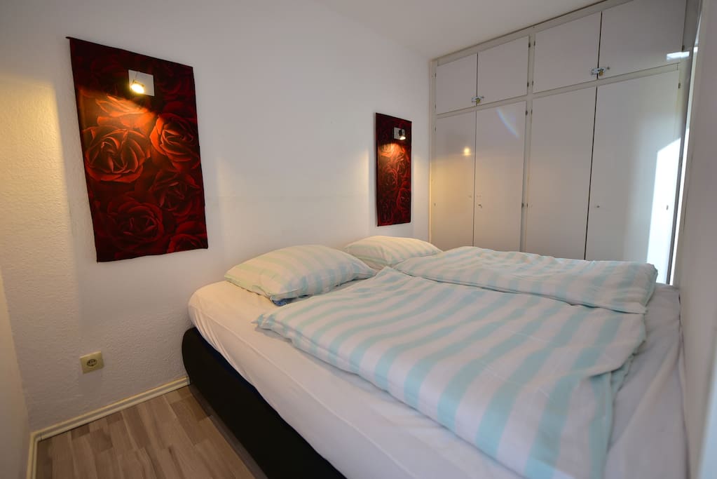 Schlafzimmer mit Kleiderschrank und Boxspringbett