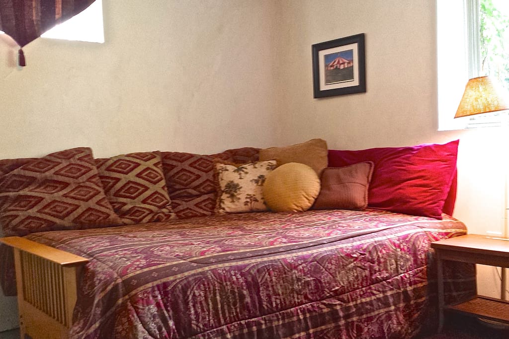 Cozy queen size bed with afternoon light. Lots of pillows for your comfort.